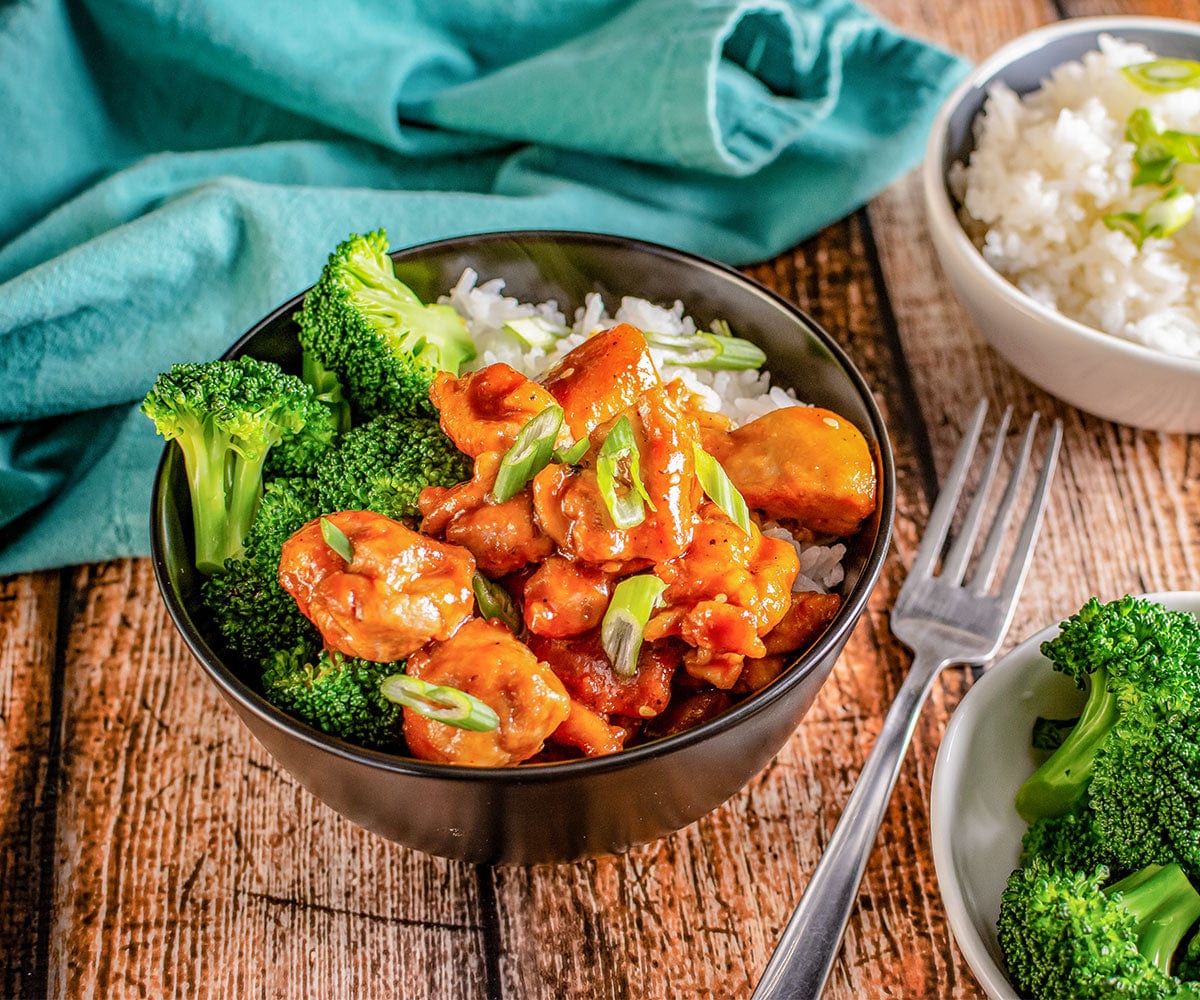 Bowl of rice, bourbon chicken, and broccoli on a table