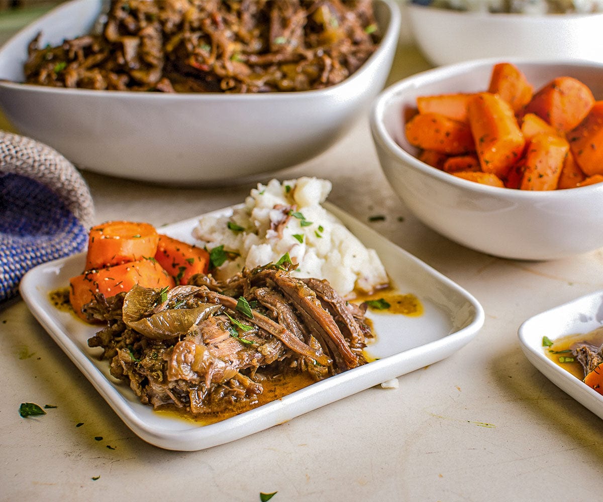 Finished plate of Sunday Pot Roast served with roasted carrots and mashed potatoes